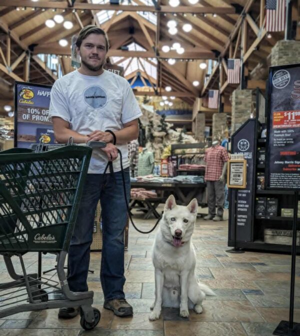 Dog and trainer practicing manners inside a retail store